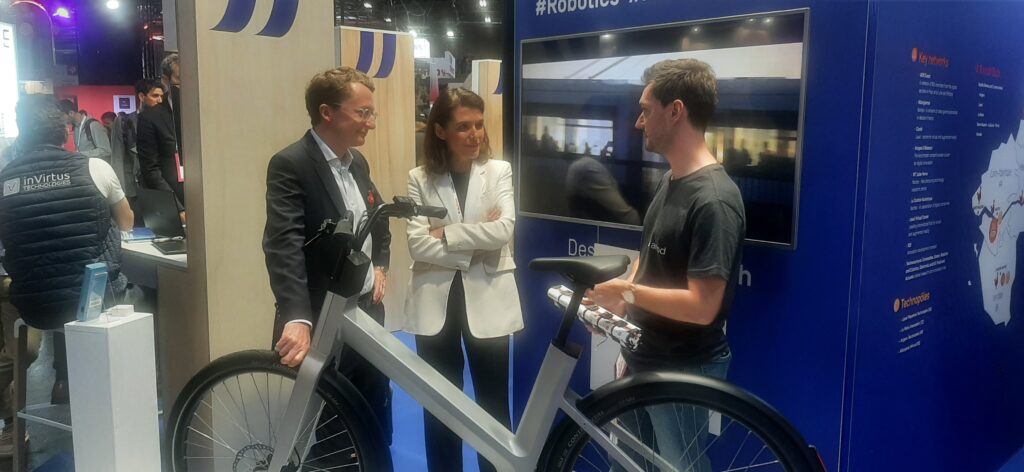 Au pavillon Pays de la Loire, la présidente Christelle Morançais admire le premier vélo hybride conçu dans sa région. Photo Philippe Martin Régions Magazine.