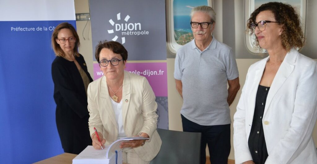 Signature par Amelle Ghayou, secrétaire générale adjointe de la préfecture de la Côte-d’Or, et Céline Tonot, vice-présidente de Dijon métropole, en présence de Michel Neugnot, vice-président de la Région Bourgogne-Franche-Comté.