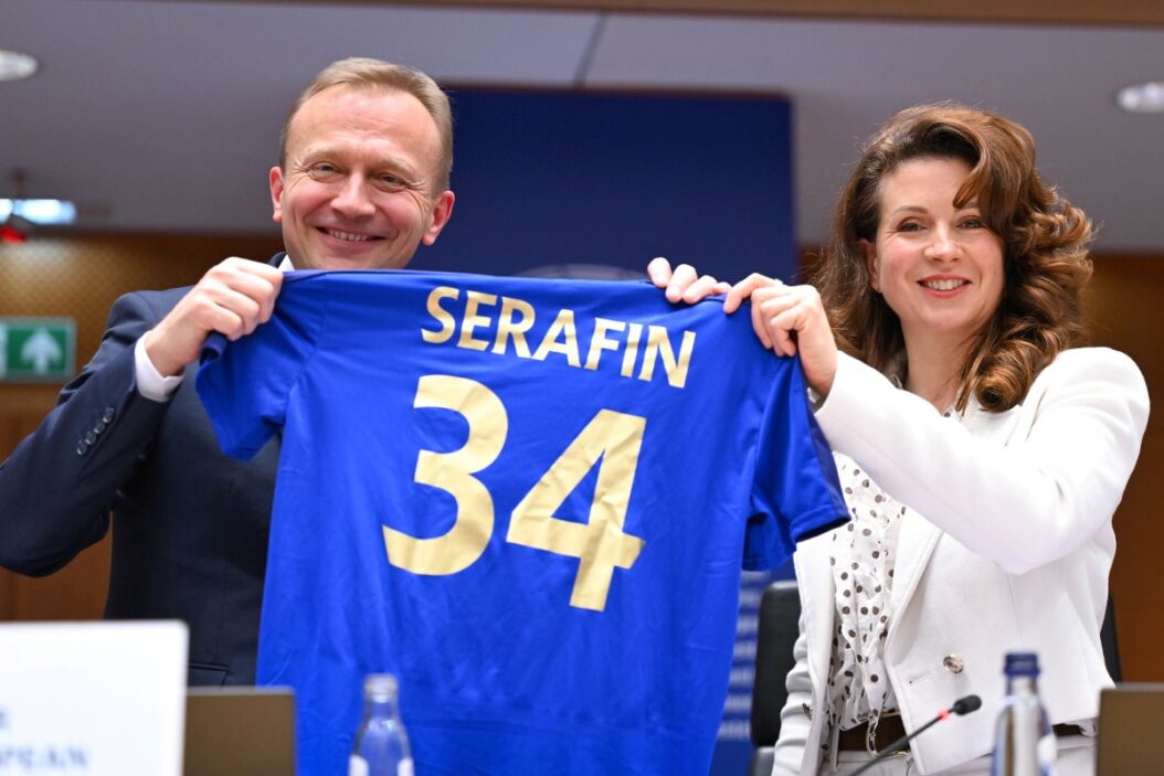 La présidente du CdR Kata Tüttő remet un maillot symbolisant la cohésion au commissaire européen Piotr Serafin. Photo UE Emile Windal
